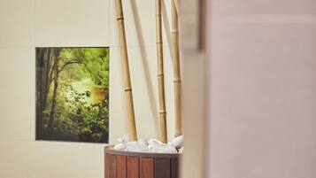 Una habitación con piso de madera, un armario de madera con toallas y un cuadro enmarcado en la pared.