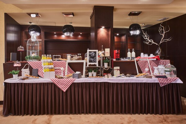 A buffet setup with a variety of food items and beverages, a decorative tree, and a sign indicating coffee and croissants. - Hotel Silken Ciudad Gijon (Gijon)