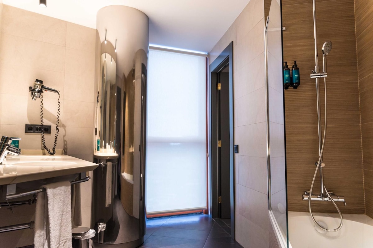 Un baño moderno con ducha, lavabo e inodoro.