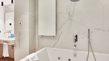 A modern bathroom with a bathtub, a shower, and a sink.