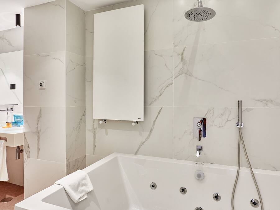 A modern bathroom with a bathtub, a shower, and a sink.