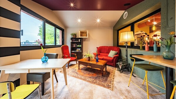 Un salon moderne avec un canapé rouge, une table basse en bois et une bibliothèque.