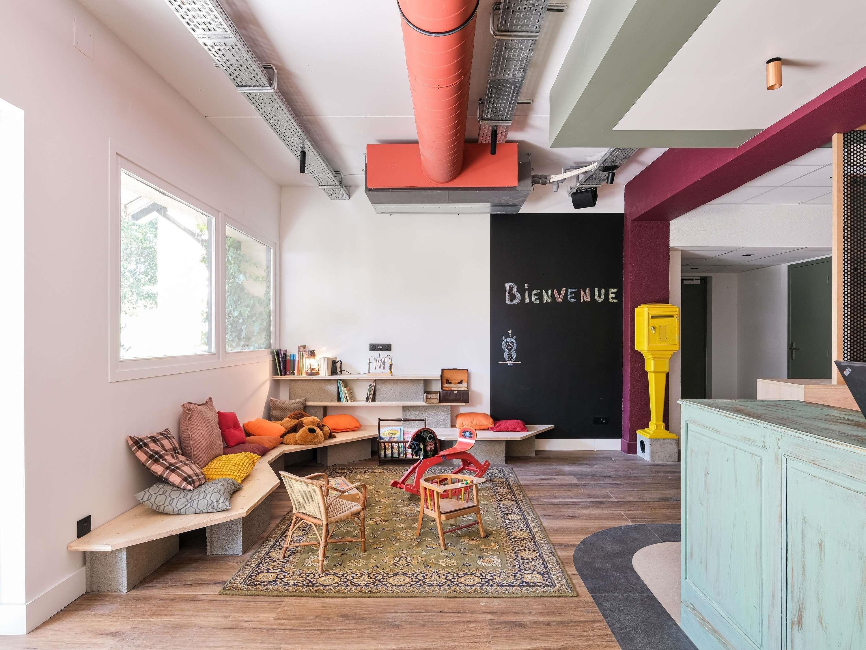 Un interior moderno con un banco empotrado, un cartel de bienvenida y un mueble de colores.