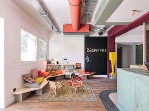 A modern interior with a built-in bench, a welcome sign, and a colorful cabinet. - greet Hotel Massieux Lyon Nord (Massieux)