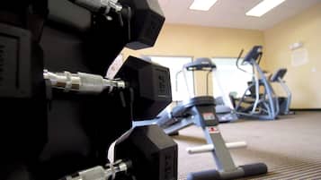 Academia com equipamentos de ginástica, incluindo halteres e esteiras.