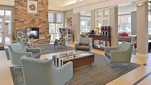 A spacious lobby with a stone fireplace, comfortable seating, and a coffee station. - Residence Inn by Marriott Loveland (Loveland)