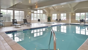 An indoor swimming pool with clear water, a diving board, and several lounge chairs. - Residence Inn by Marriott Loveland (Loveland)