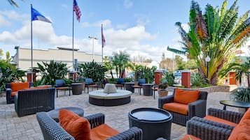 An outdoor patio area with wicker furniture, a round seating area, and flags.