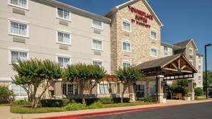 A hotel with a stone facade, multiple windows, and a covered entrance area.