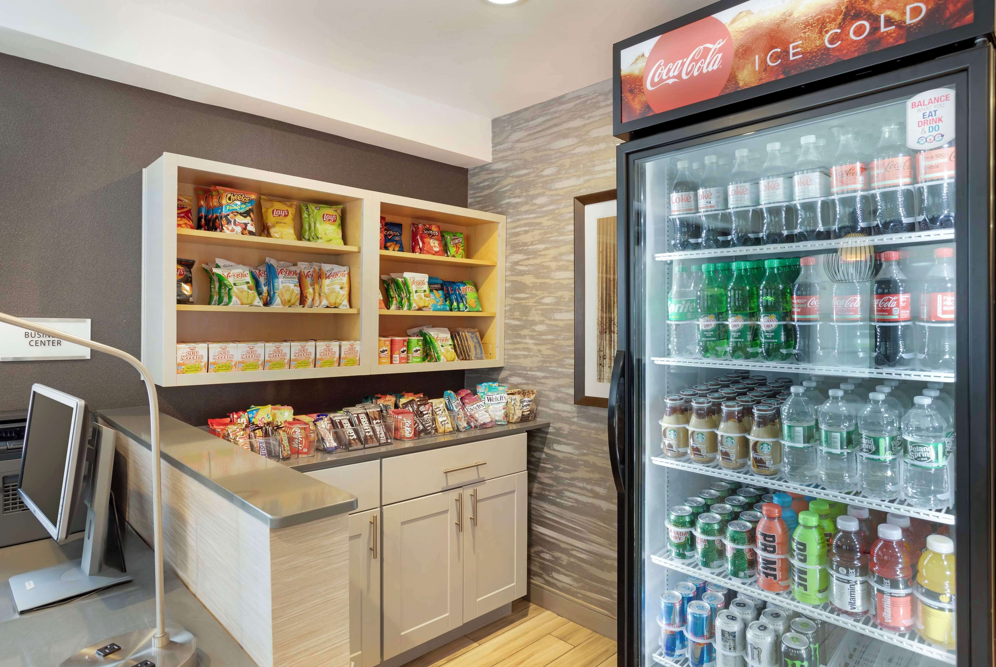Een automaatruimte met schappen vol chips, snacks en diverse dranken, waaronder Coca-Cola en andere merken.