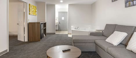 A modern living room with a grey sofa, a yellow side table, and a remote control on the table.