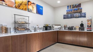 A modern kitchen area with a wooden counter, a coffee station, and various appliances. - Comfort Inn & Suites Shelbyville (Shelbyville)