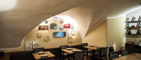A restaurant with a curved ceiling, wooden tables and chairs, and wall-mounted decor.