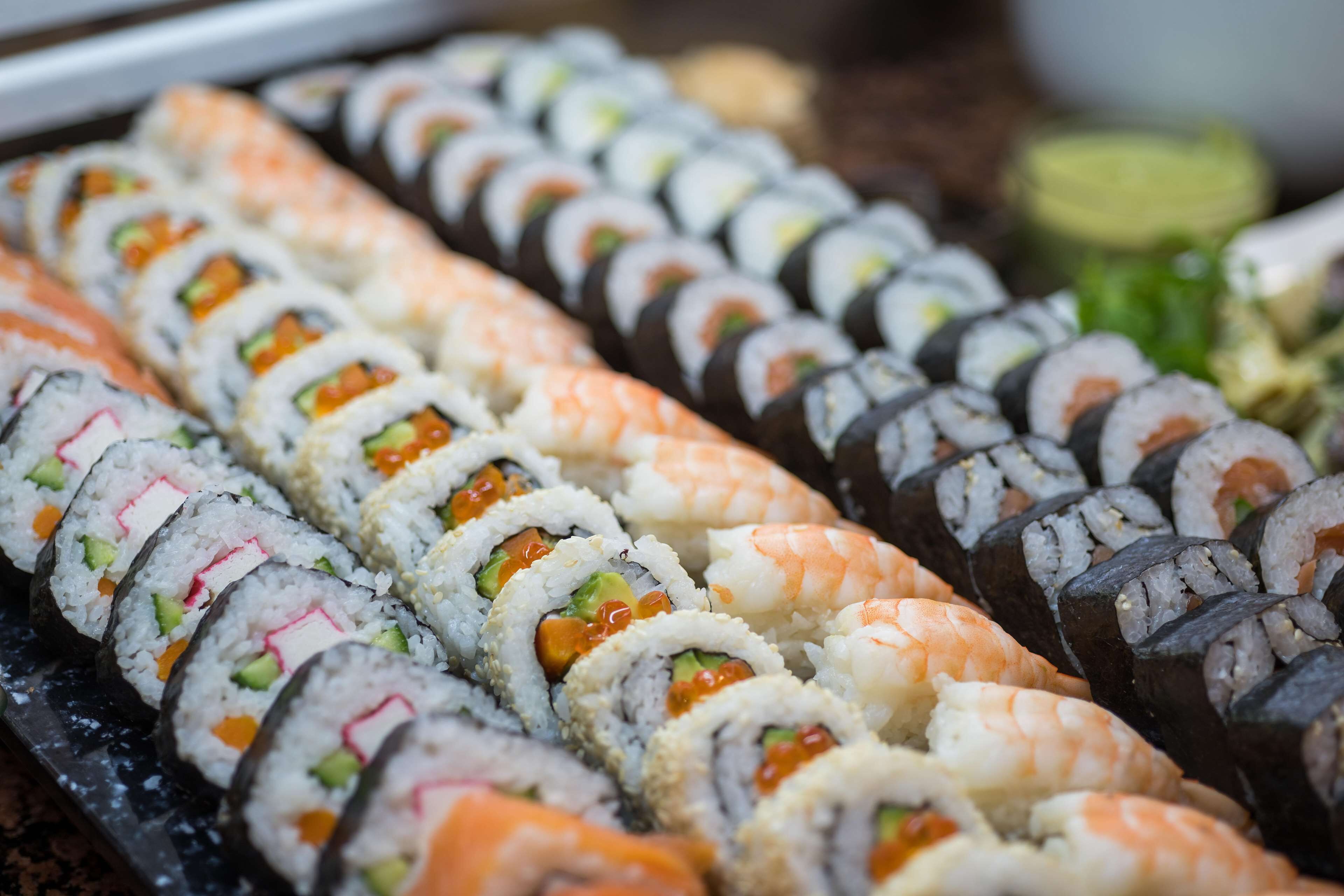 A variety of sushi rolls displayed on a tray.