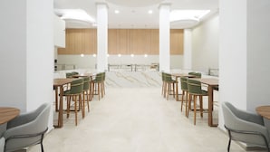 Un comedor moderno con techos altos, iluminación empotrada y una isla central.