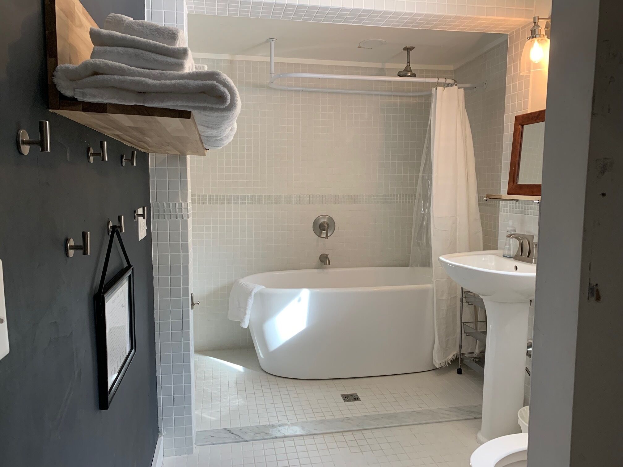 A modern bathroom with a bathtub, shower, and sink.