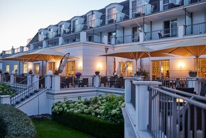 Ein mehrstöckiges Hotel mit Außenbereichen, einer Treppe und einem gepflegten Garten.