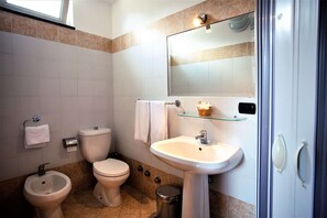 A bathroom with a toilet, bidet, sink, and mirror. - Hotel Marabel (Sant'Alessio Siculo)