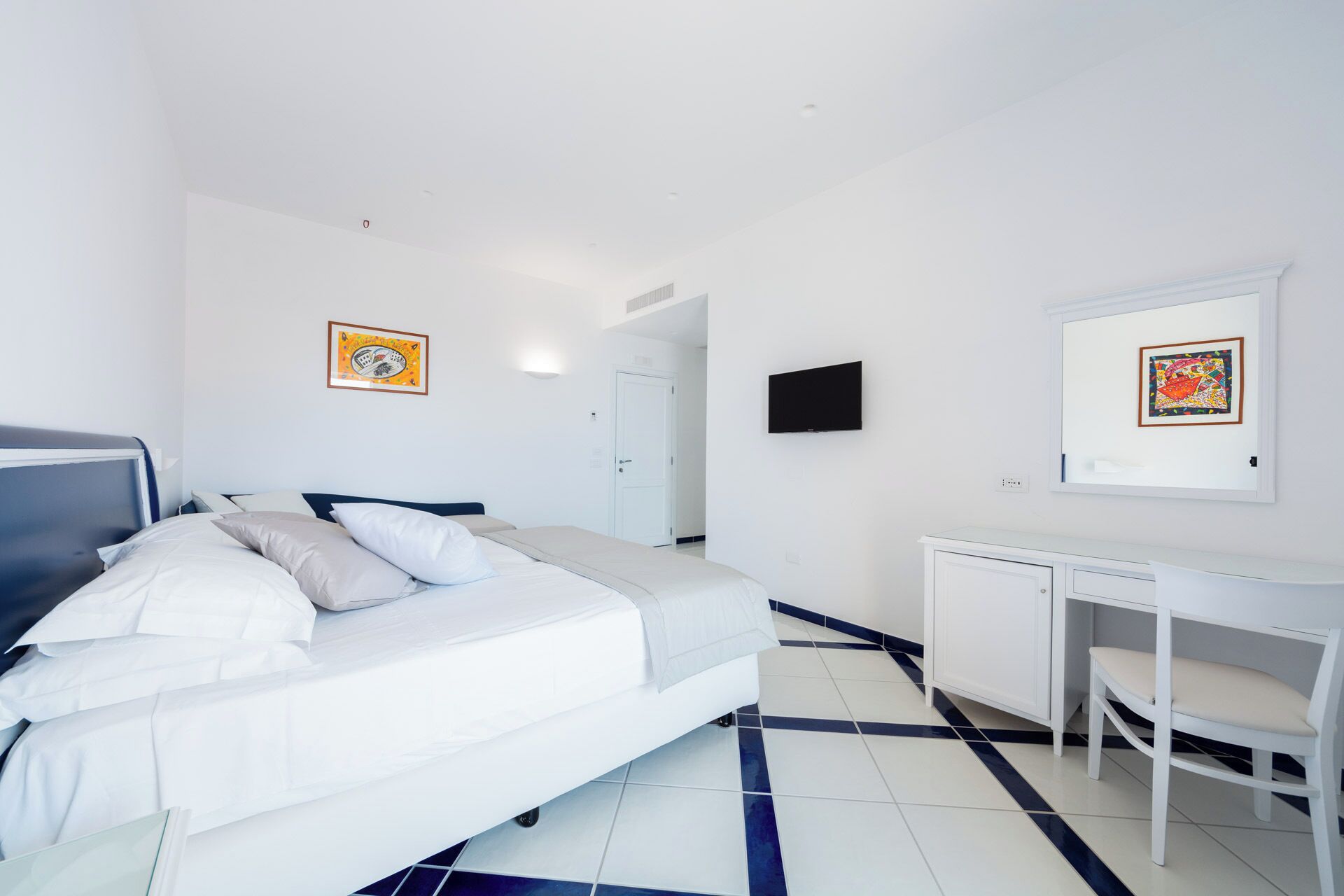 Una habitación de hotel con cama, escritorio y televisión.