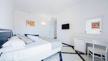 Una habitación de hotel con cama, escritorio y televisión.