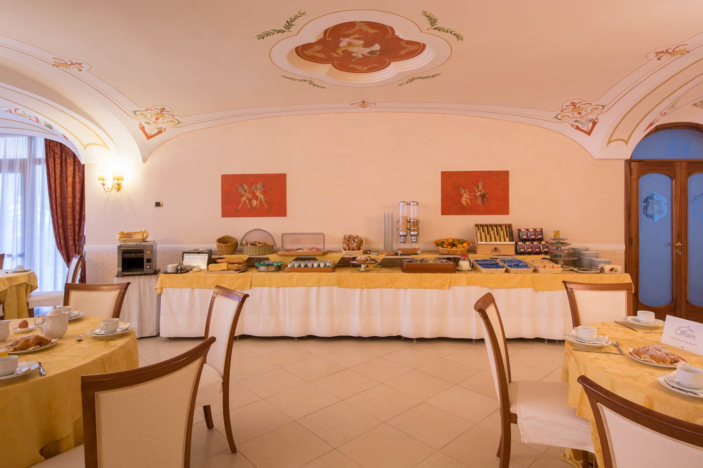 Un bufé de desayuno con diferentes opciones de comida, una estación de café y un techo decorativo.