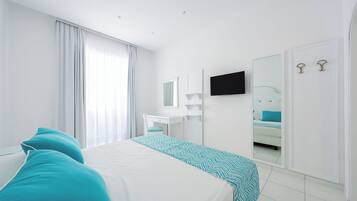 Una habitación de hotel moderna con una cama grande, un escritorio, un espejo y un televisor.