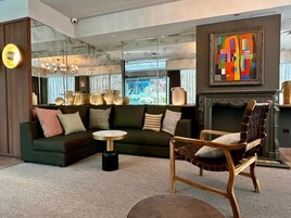 Ein modernes Wohnzimmer mit einer Eckcouch, einem runden Couchtisch und einem Holzsesseln.