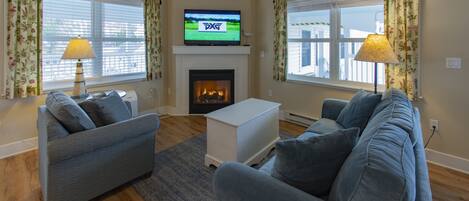 A living room with two sofas, a TV, and a fireplace.
