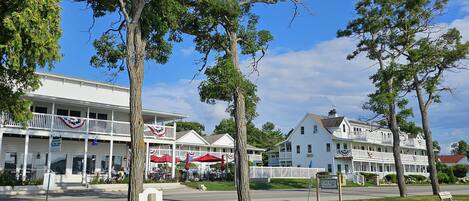 A waterfront hotel with a balcony, outdoor seating, and a sign for 'Fish Bowl Lounge'.