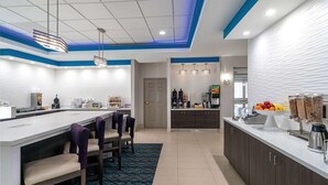 Una cocina moderna con una isla central, taburetes de bar y una barra desayunadora.