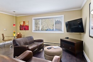 Suite urbana, 1 habitación | Área de sala de estar | Televisión de pantalla plana de 50 pulgadas con canales por cable 