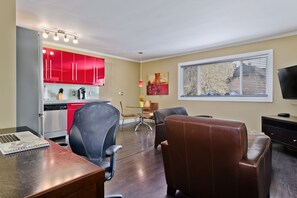 Suíte urbana, 1 quarto | Área de estar | TV de tela plana 50 polegadas com canais a cabo, TV