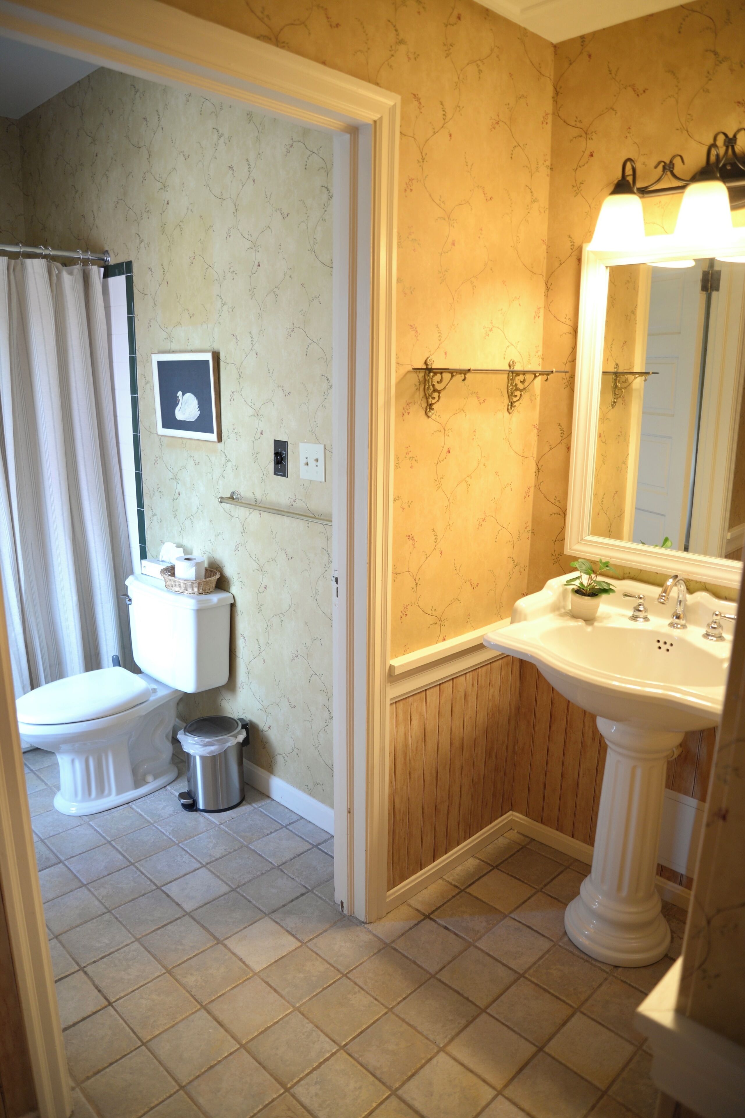 A bathroom with a toilet, sink, and shower curtain.