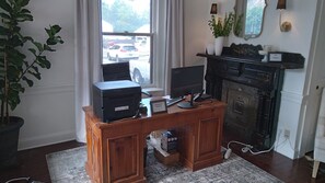 A wooden desk with a computer, a phone, and a sign indicating the manager's phone number. - Strasburg Village Inn (Strasburg)