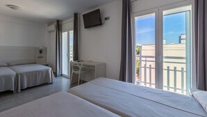 A hotel room with two beds, a desk, a chair, and a TV. - Hotel Apartamentos Solimar (Calafell)