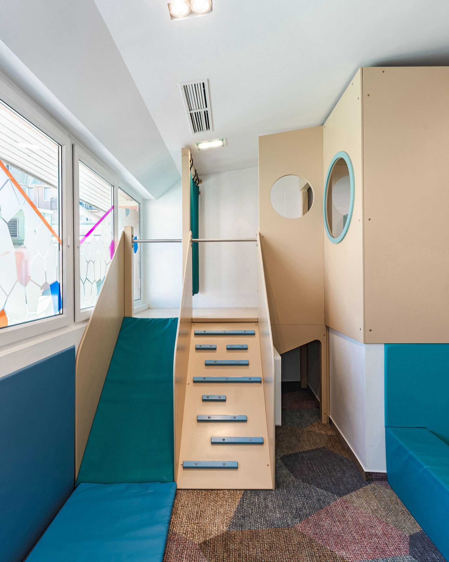 Zona de juegos infantiles con un tobogán y escaleras de acceso.
