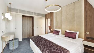 A modern bedroom with a large bed, a bedside table, a mirror, and a built-in wardrobe.