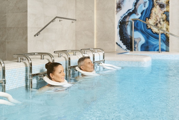 A swimming pool with safety railings and a mosaic wall. - Hotel Európa Fit (Hévíz)