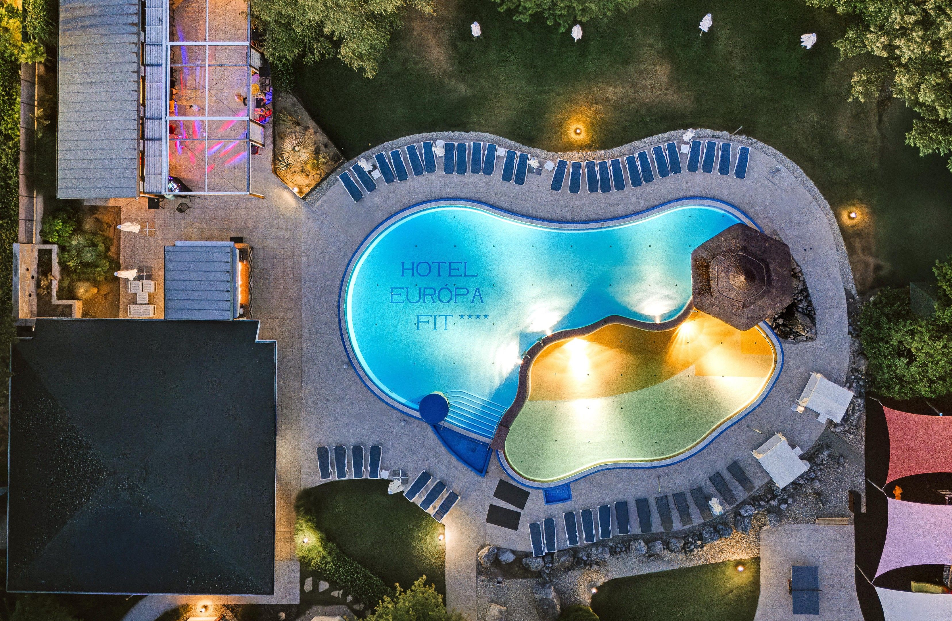 A swimming pool with a sign reading 'HOTEL EUROPA FIT'.