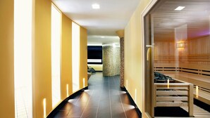 A hallway with a wooden bench, a spa area, and a reception desk. - Hotel Európa Fit (Hévíz)