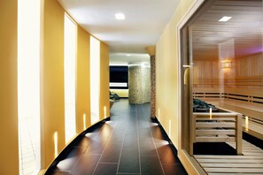 A hallway with a wooden bench, a spa area, and a reception desk. - Hotel Európa Fit (Hévíz)