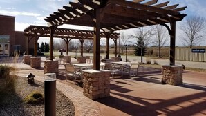 An outdoor patio area with a pergola, stone pillars, and seating arrangements. - Country Inn & Suites by Radisson, Green Bay East, WI (Green Bay)