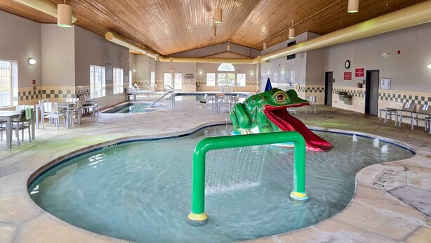A swimming pool with a frog slide, indoor seating, and a wooden ceiling. - Country Inn & Suites by Radisson, Green Bay East, WI (Green Bay)