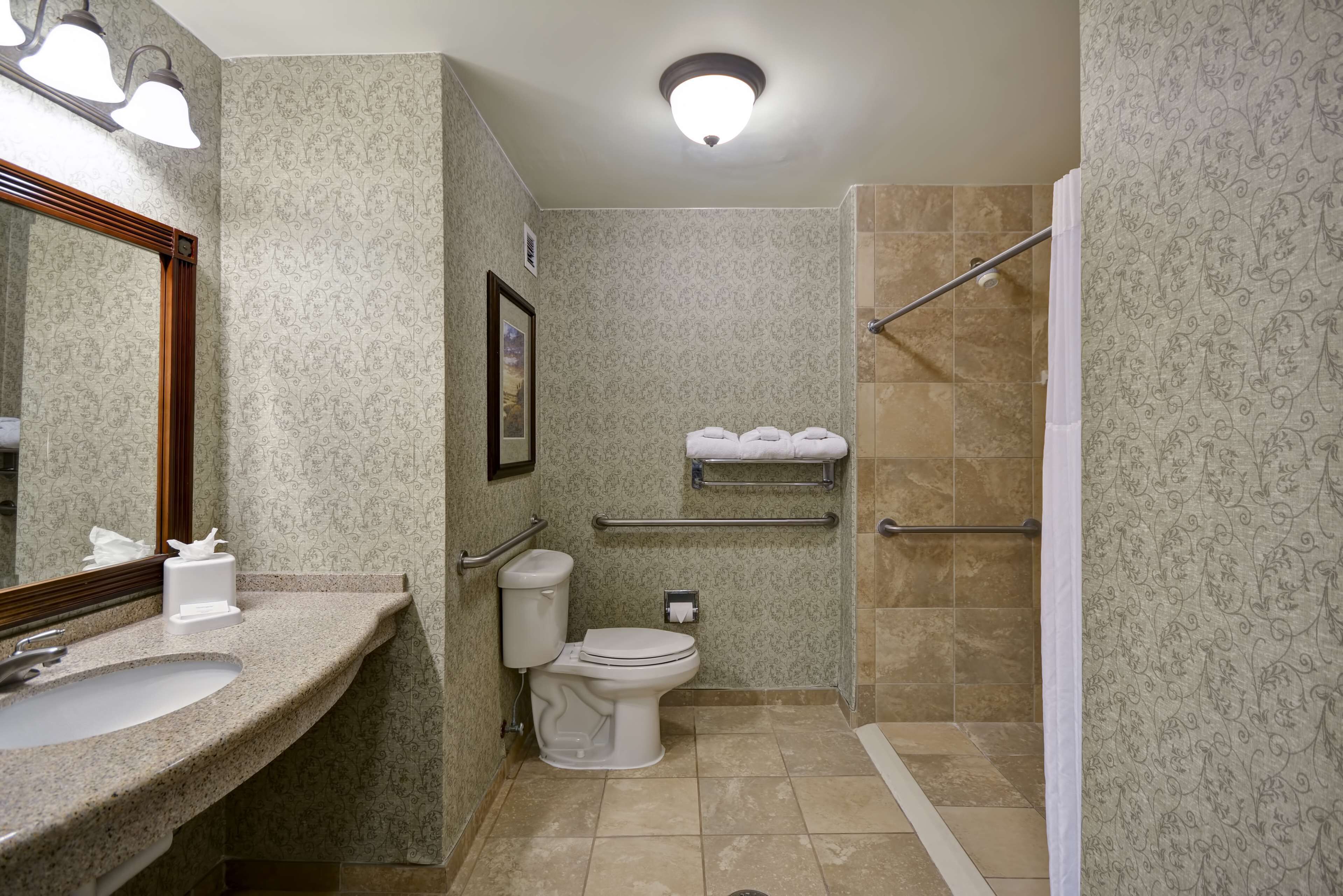 A bathroom with a sink, toilet, and shower area.