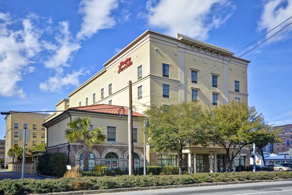 A hotel with a classic architectural style, featuring a prominent entrance with a covered porch and a large arched window.