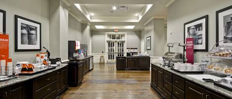 A spacious kitchen with dark wooden cabinets, granite countertops, and a central island.