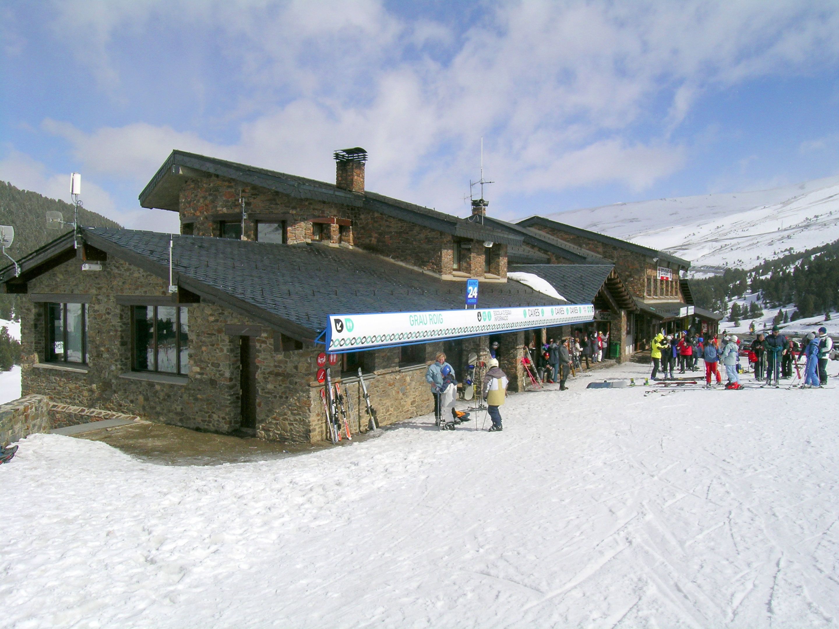 Un bâtiment en pierre avec une piste de ski devant.