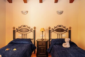 A bedroom with two beds, a nightstand with a lamp, and a teddy bear on one bed. - Apartamentos Ona Dorada el Tarter (Ransol)