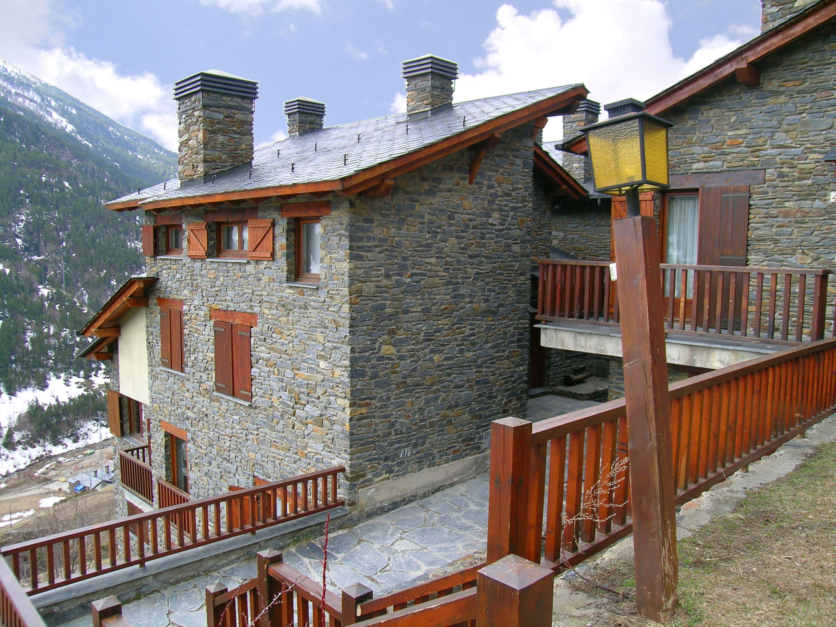 Un edificio de piedra con balcones de madera y una chimenea de piedra.