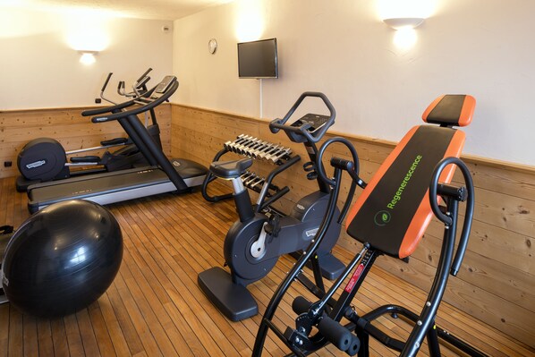 A gym with exercise equipment including treadmills, an elliptical, and a stationary bike. - Hôtel Beaulieu (La Clusaz)